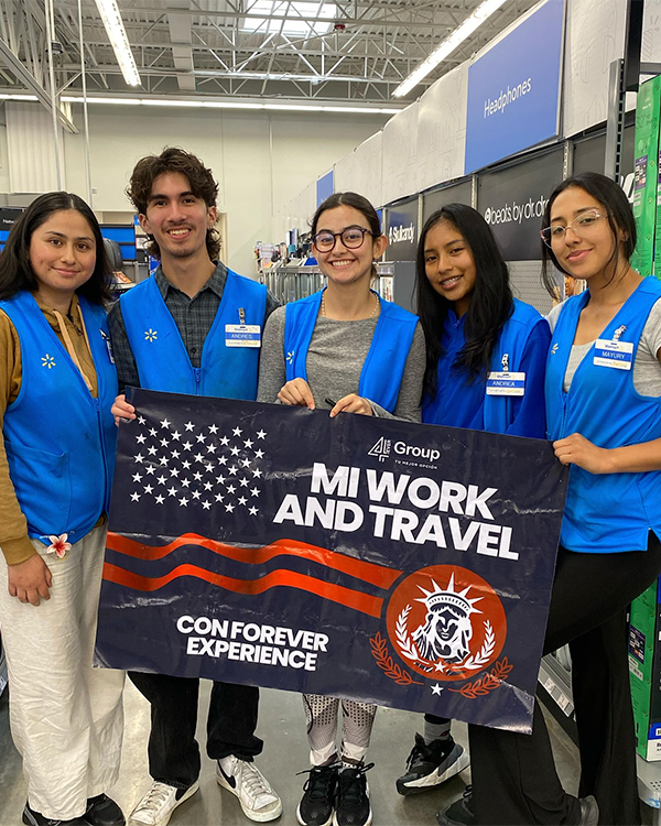 Estudiantes felices sosteniendo una bandera que dice 'Mi Work and Travel' | Experiencia laboral y cultural internacional con Forever Experience