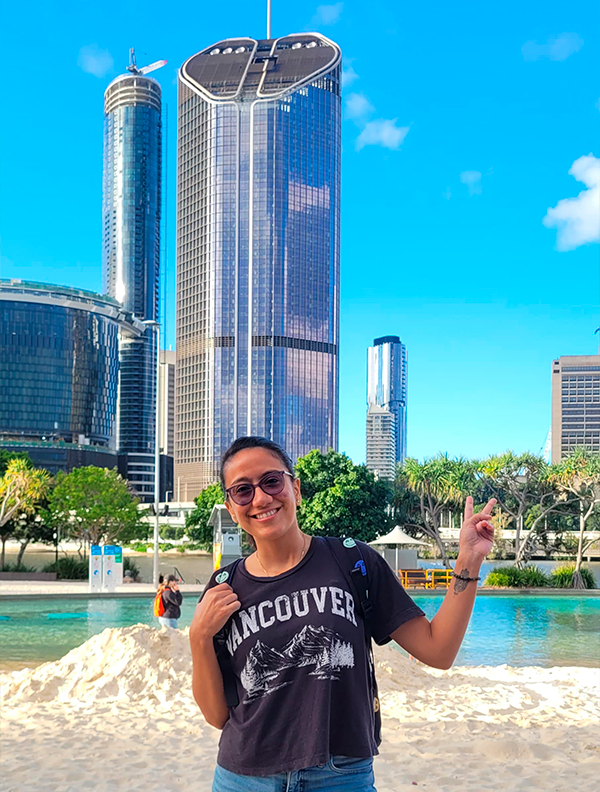 Estudiante posando frente a los rascacielos en su experiencia internacional con Forever Experience.